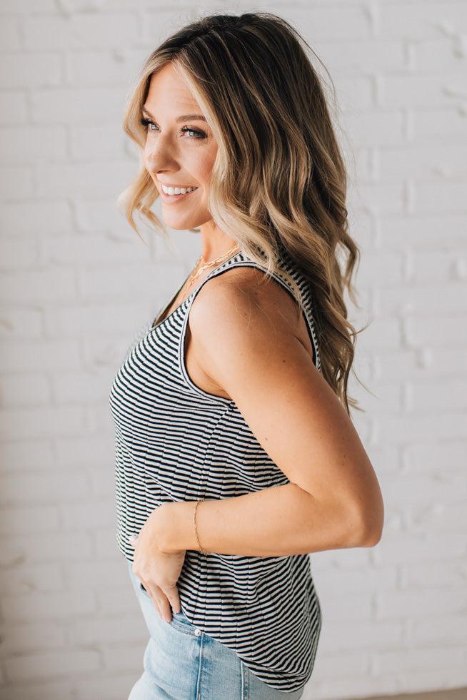 BLONDE WOMAN WEARING A SCOOP NECK, SLEEVELESS, TEXTURED BLACK AND WHITE STRIPE TANK TOP.