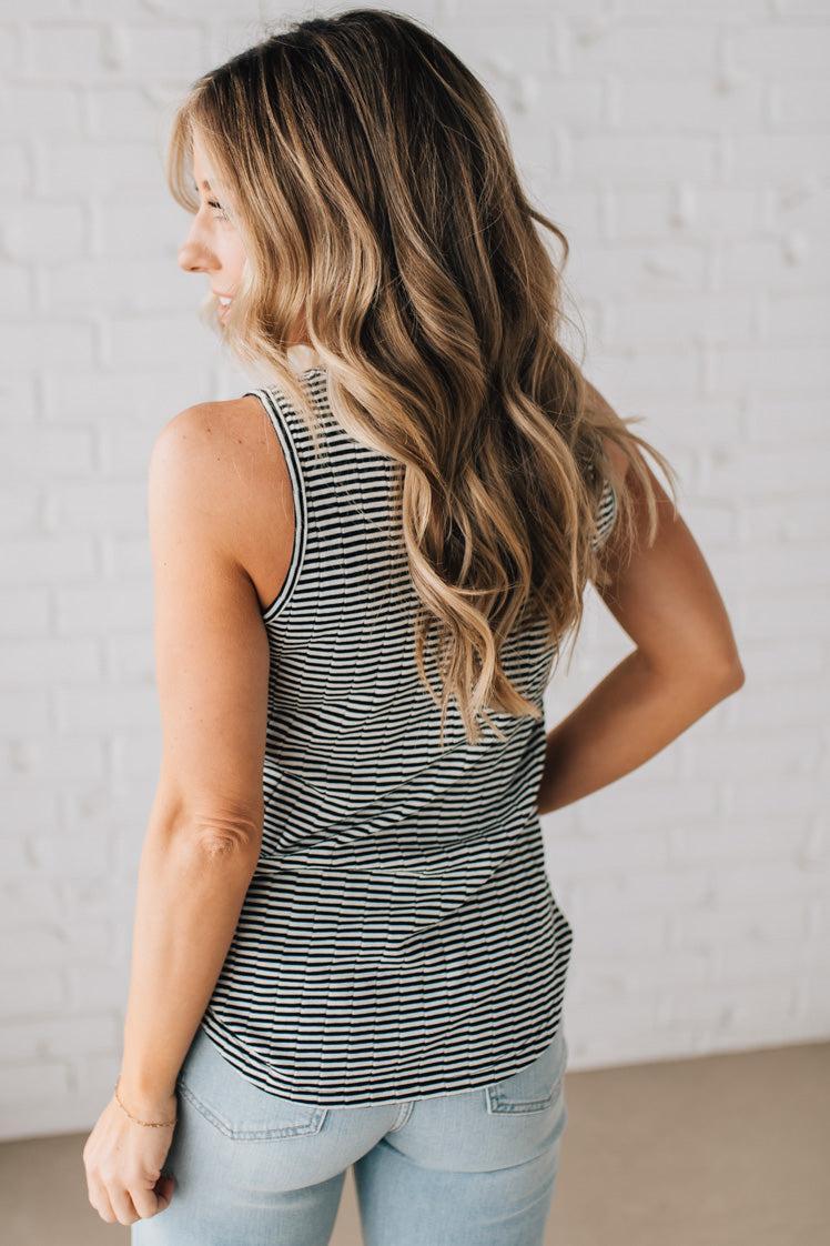 BLONDE WOMAN WEARING A SCOOP NECK, SLEEVELESS, TEXTURED BLACK AND WHITE STRIPE TANK TOP.