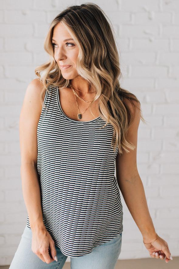 BLONDE WOMAN WEARING A SCOOP NECK, SLEEVELESS, TEXTURED BLACK AND WHITE STRIPE TANK TOP.