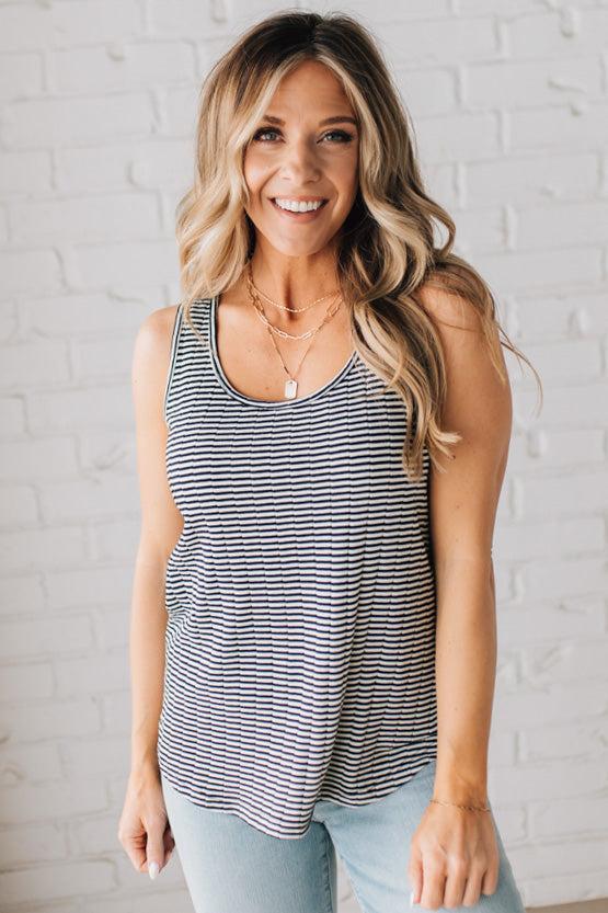 BLONDE WOMAN WEARING A SCOOP NECK, SLEEVELESS, TEXTURED BLACK AND WHITE STRIPE TANK TOP.