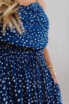 Navy blue dress with white polka dots worn by a person.