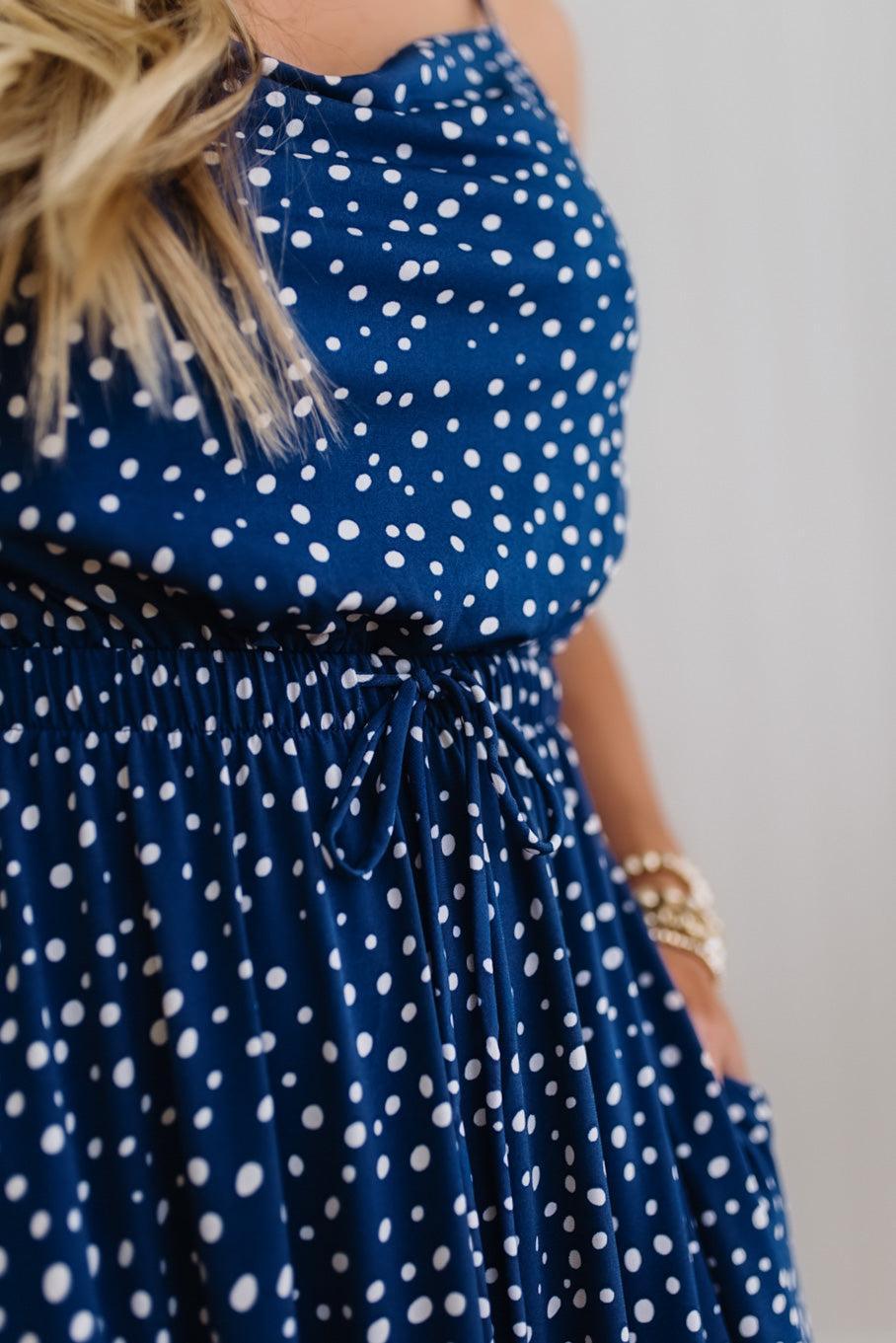 Navy blue dress with white polka dots worn by a person.