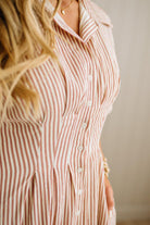 Person wearing a red and white striped shirt with a neutral background