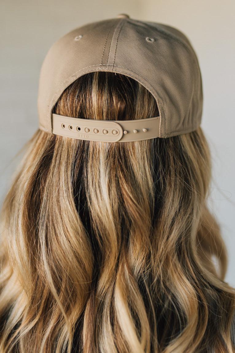 Person wearing a beige cap with a neutral background