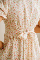 Floral dress with a tie waist on a plain background