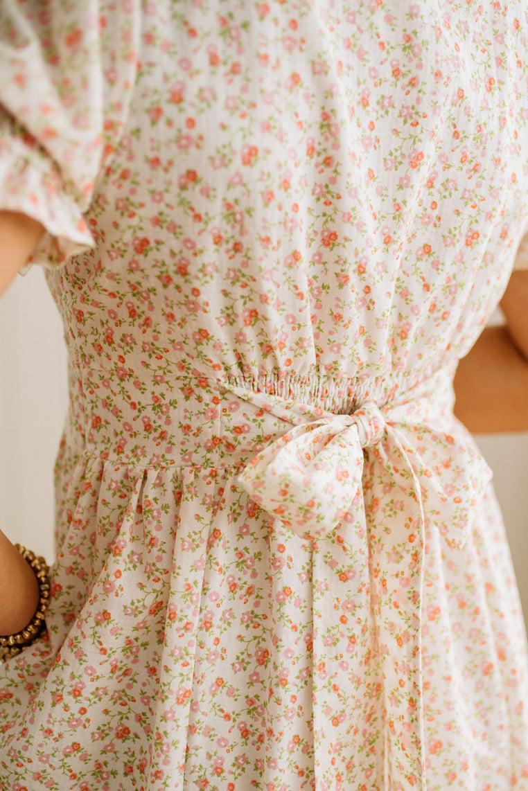 Floral dress with a tie waist on a plain background