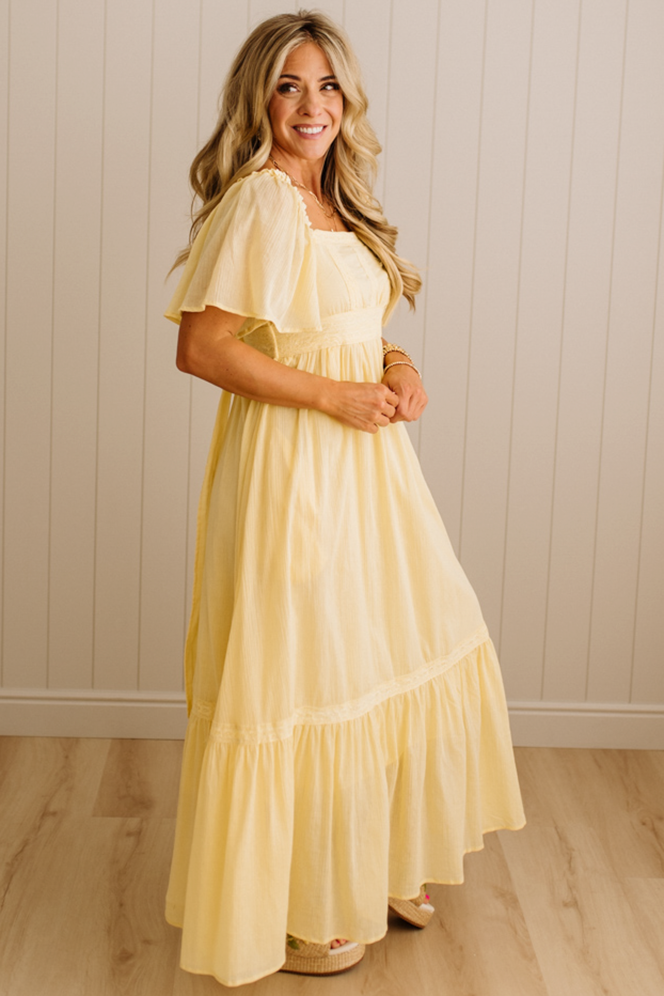 Blonde Woman Wearing a Lemon Yellow Lace Inset Flutter Sleeve Maxi Dress