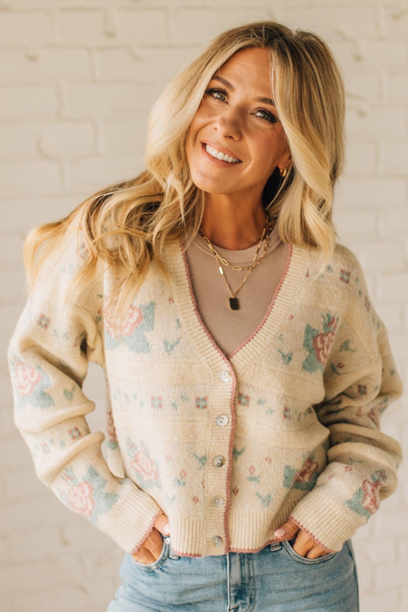 Woman wearing a patterned beige cardigan with a neutral background