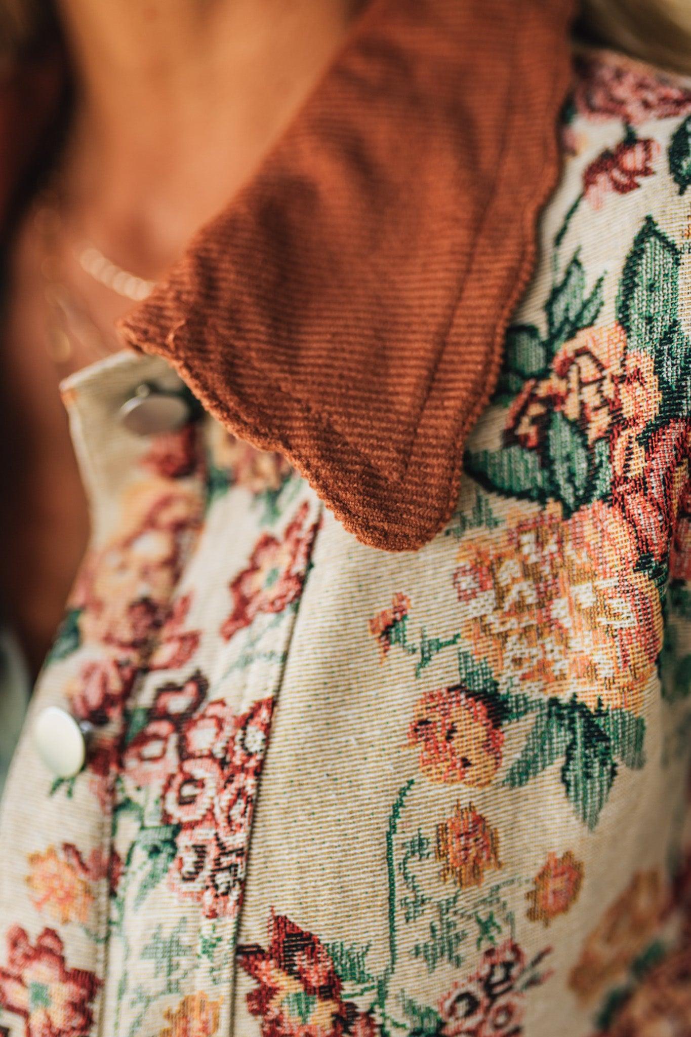 Close-up of a floral patterned fabric with a brown corduroy textured collar.