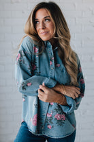 blonde girl modeling a long sleeve button front denim top with pink floral pattern