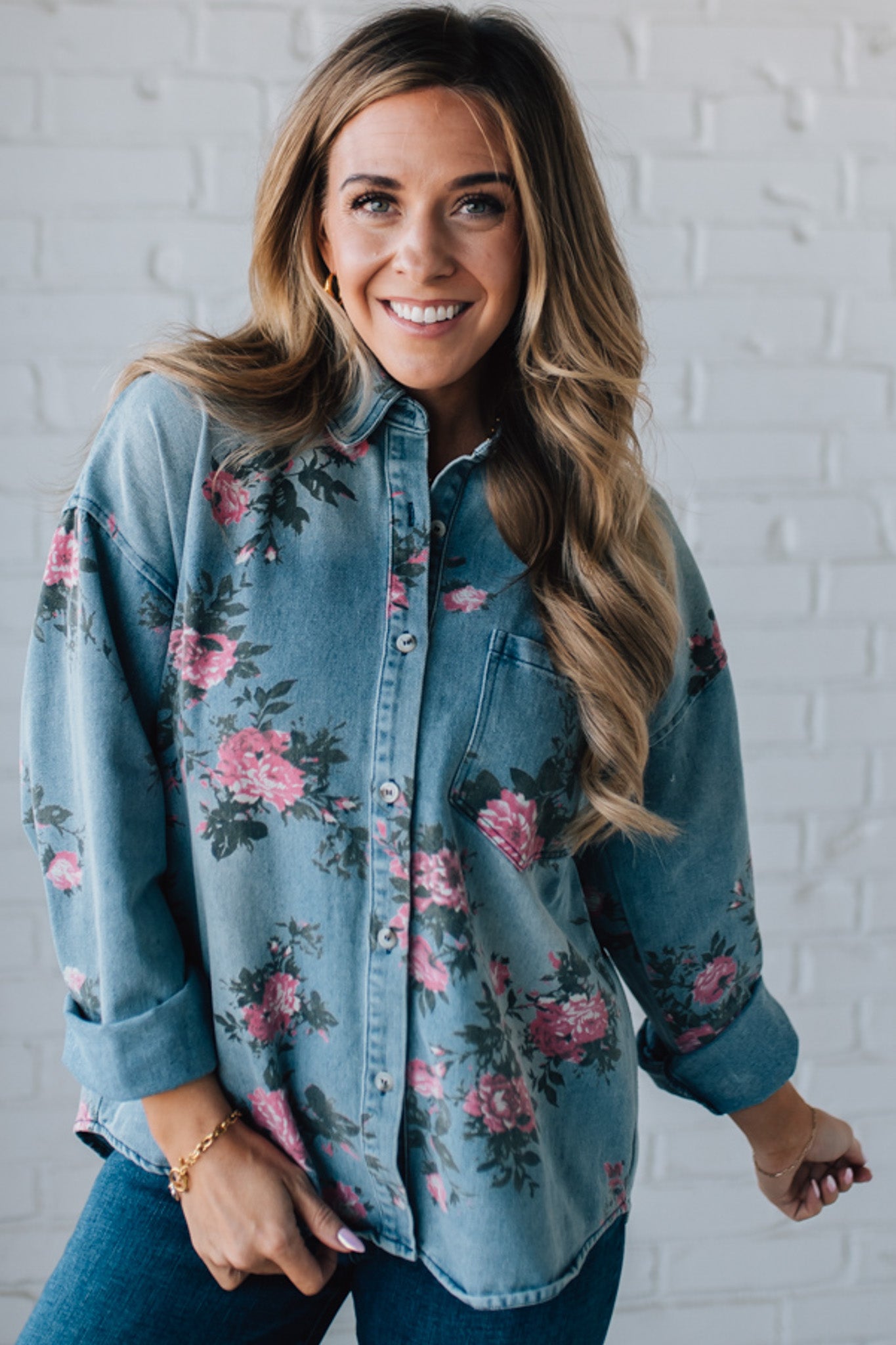 blonde girl modeling a long sleeve button front denim top with pink floral pattern