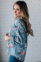 blonde girl modeling a long sleeve button front denim top with pink floral pattern