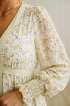 Floral patterned blouse with long sleeves on a neutral background