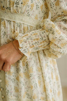 Close-up of a person wearing a floral dress with a neutral background