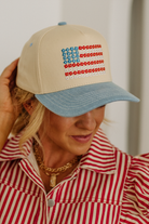 Person wearing a beige cap with a red, white, and blue pattern resembling an American flag.