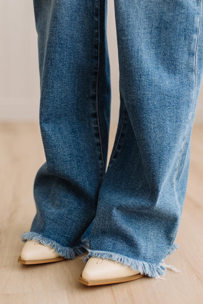 Finged jeans close up with cream embroidered western inspired slip on heel boots.