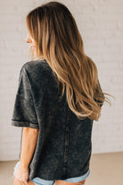 BLONDE WOMAN WEARING A FRENCH TERRY, ACID-WASHED TEE SHIRT WITH RAW EDGE ON NECKLINE AND A BOXY FIT.