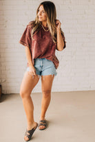 BLONDE WOMAN WEARING A FRENCH TERRY, ACID-WASHED TEE SHIRT WITH RAW EDGE ON NECKLINE AND A BOXY FIT.