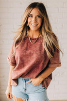 BLONDE WOMAN WEARING A FRENCH TERRY, ACID-WASHED TEE SHIRT WITH RAW EDGE ON NECKLINE AND A BOXY FIT.