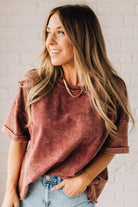 BLONDE WOMAN WEARING A FRENCH TERRY, ACID-WASHED TEE SHIRT WITH RAW EDGE ON NECKLINE AND A BOXY FIT.