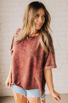 BLONDE WOMAN WEARING A FRENCH TERRY, ACID-WASHED TEE SHIRT WITH RAW EDGE ON NECKLINE AND A BOXY FIT.