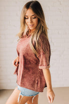 BLONDE WOMAN WEARING A FRENCH TERRY, ACID-WASHED TEE SHIRT WITH RAW EDGE ON NECKLINE AND A BOXY FIT.