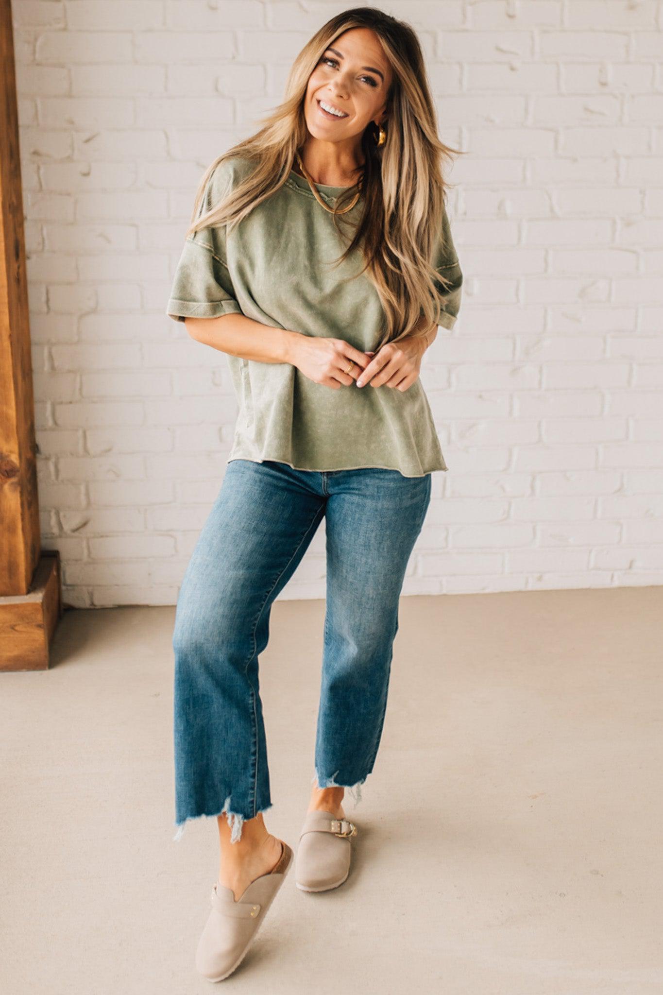 BLONDE WOMAN WEARING A FRENCH TERRY, ACID-WASHED TEE SHIRT WITH RAW EDGE ON NECKLINE AND A BOXY FIT.