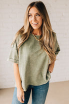 BLONDE WOMAN WEARING A FRENCH TERRY, ACID-WASHED TEE SHIRT WITH RAW EDGE ON NECKLINE AND A BOXY FIT.