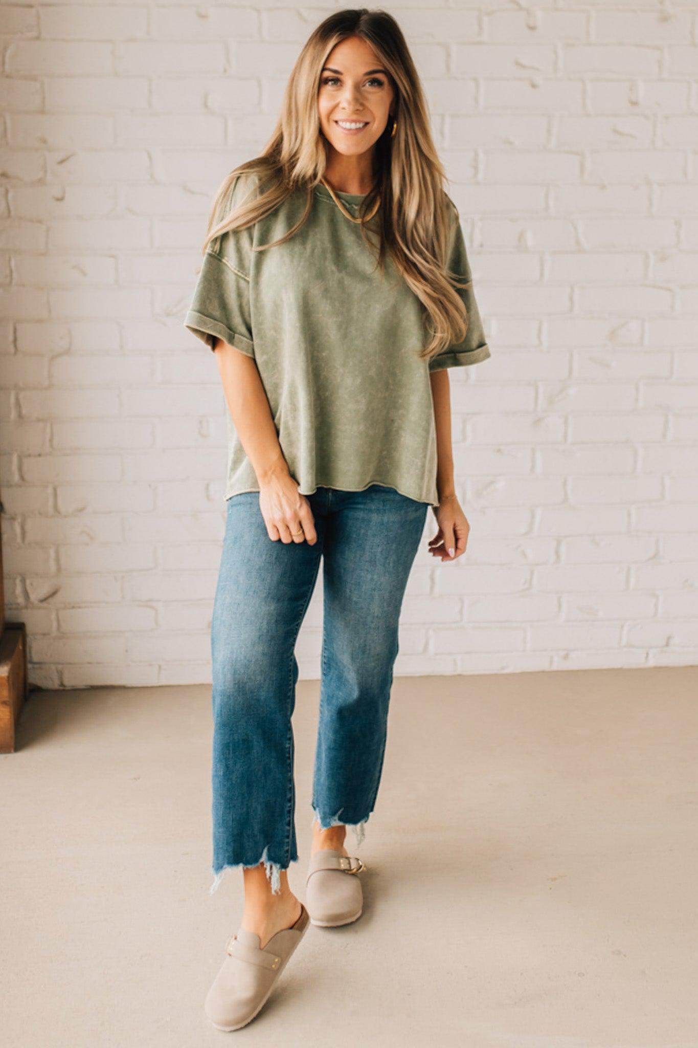 BLONDE WOMAN WEARING A FRENCH TERRY, ACID-WASHED TEE SHIRT WITH RAW EDGE ON NECKLINE AND A BOXY FIT.