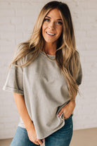 BLONDE WOMAN WEARING A FRENCH TERRY, ACID-WASHED TEE SHIRT WITH RAW EDGE ON NECKLINE AND A BOXY FIT.