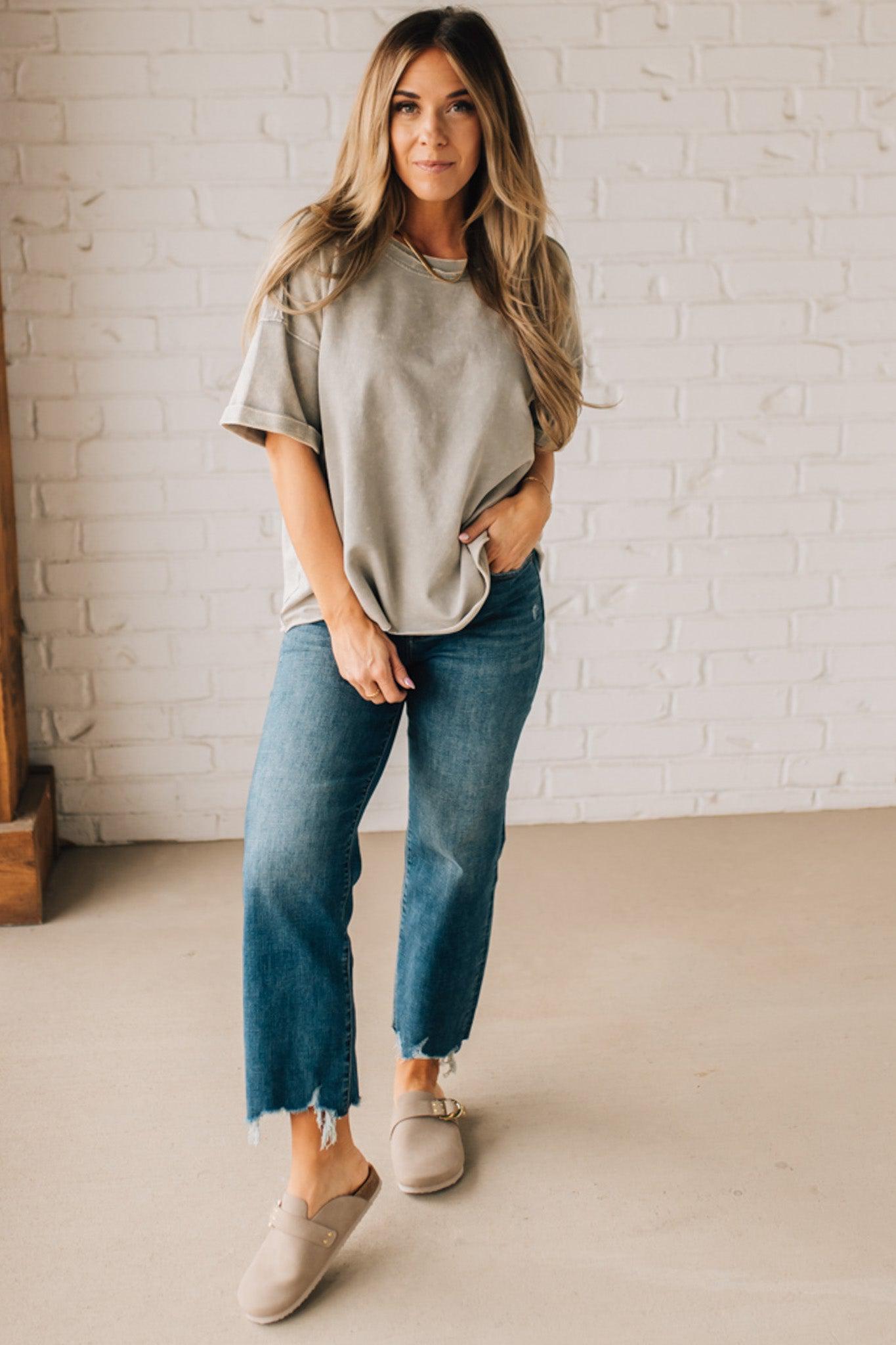 BLONDE WOMAN WEARING A FRENCH TERRY, ACID-WASHED TEE SHIRT WITH RAW EDGE ON NECKLINE AND A BOXY FIT.