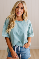 Woman wearing a light blue t-shirt and denim shorts indoors