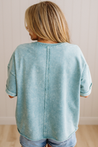 Person wearing a light blue denim shirt with a neutral background