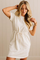 Woman wearing a white dress against a neutral background