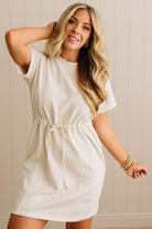 Woman wearing a white dress with a neutral background