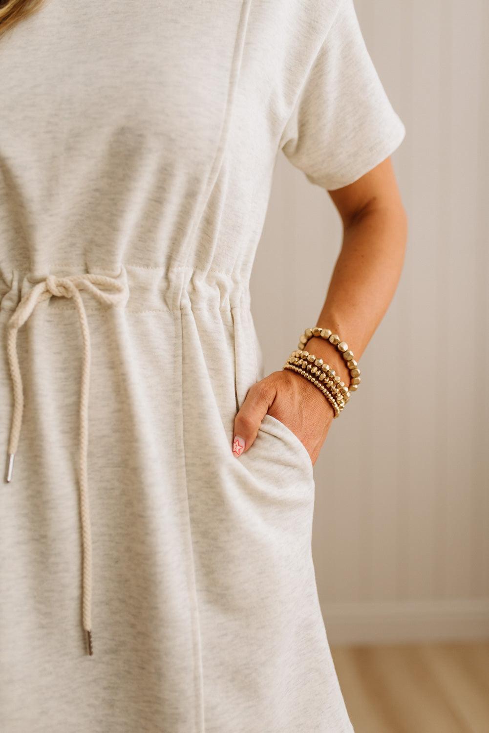 Person wearing a beige dress with a plain background