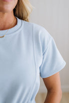 Light blue t-shirt worn by a person with a neutral background
