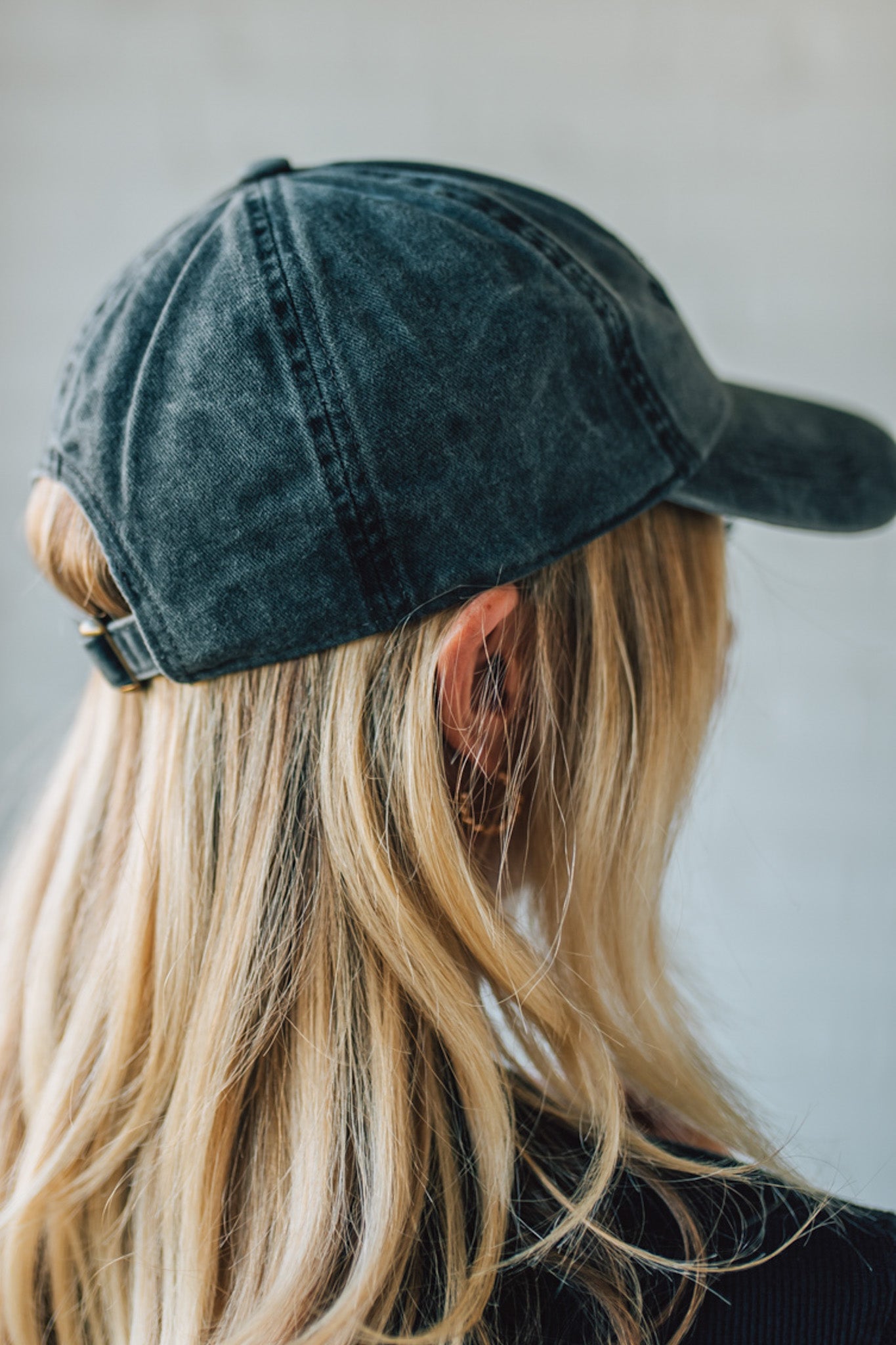 Person wearing a denim cap with a plain background