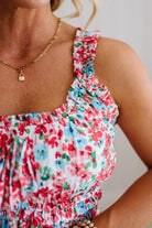 Close-up of a person wearing a colorful floral dress with a neutral background