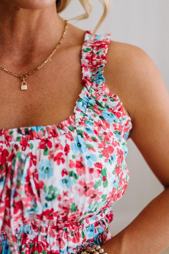 Close-up of a person wearing a colorful floral dress with a neutral background
