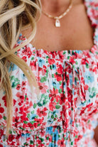 Close-up of a person wearing a colorful floral dress with a necklace.