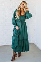 Blonde Woman Wearing a Gathered Long Sleeve Maxi Dress in the color Deep Forest.