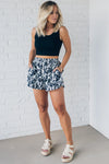 Black and white floral shorts with side pockets, and smocked waistband.