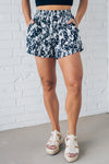 Black and white floral shorts with side pockets, and smocked waistband.