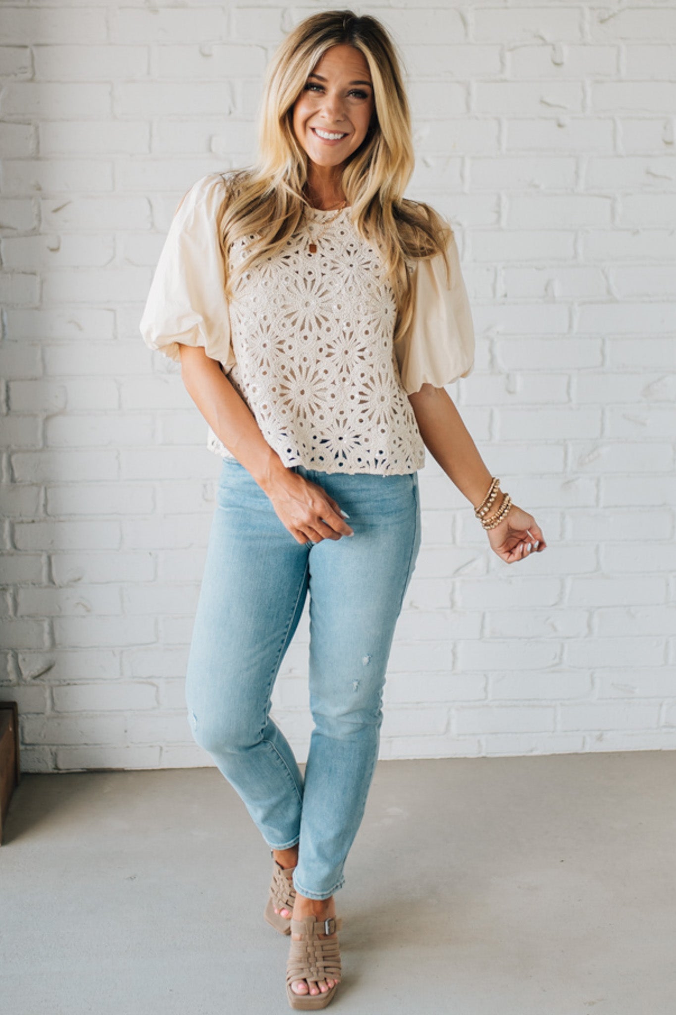 Blonde woman wearing a Mix Media Sequin Crochet Bodice Woven Blouse in cream.