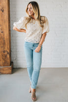 Blonde woman wearing a Mix Media Sequin Crochet Bodice Woven Blouse in cream.
