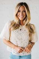 Blonde woman wearing a Mix Media Sequin Crochet Bodice Woven Blouse in cream.