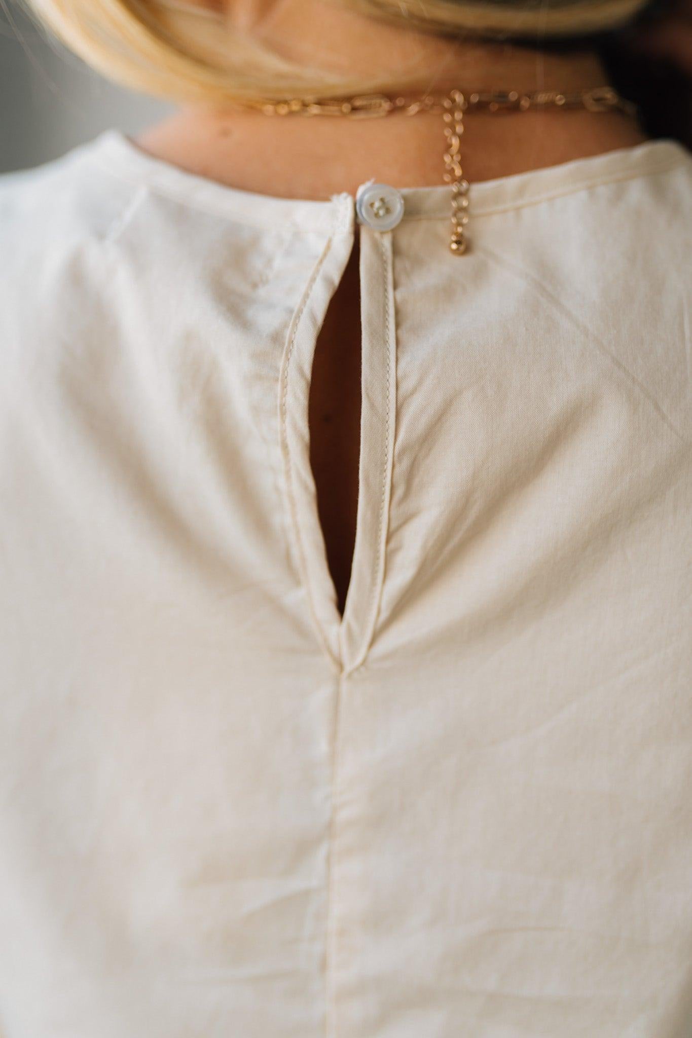 Blonde woman wearing a Mix Media Sequin Crochet Bodice Woven Blouse in cream.