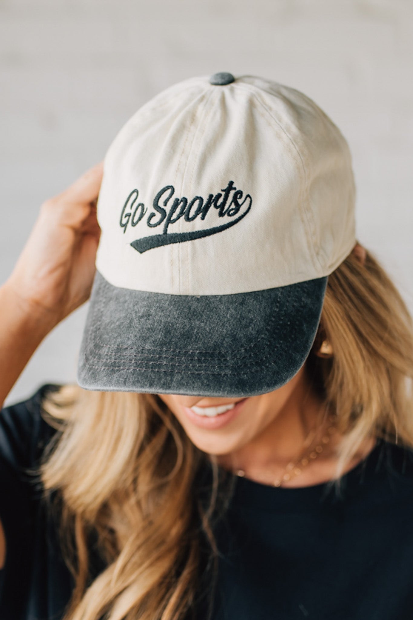 Blonde woman wearing a hat with Go Sports Embroidered at the front of the  Two Tone Baseball Cap.