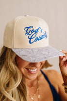 Woman wearing a cap with 'God's Country' text and map design.